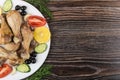 Fried chicken legs with vegetable, olives and lemon in dish Royalty Free Stock Photo