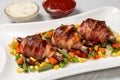 Fried chicken legs wrapped in bacon with vegetables Royalty Free Stock Photo