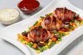 Fried chicken legs wrapped in bacon with vegetables Royalty Free Stock Photo
