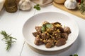 Stir fry sliced liver with peppercorn and garlic in white plate
