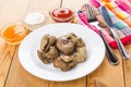 Fried chicken liver, knife, fork on napkin, bowls with sauce