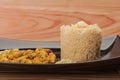 Fried chicken meat and couscous on black plate on wooden table Royalty Free Stock Photo