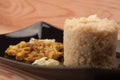 Fried chicken meat and couscous on black plate on wooden table Royalty Free Stock Photo