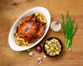 Fried chicken meat and roasted potatoes on a white platter, a glass of beer, champignon mushrooms and green onions, delicious food Royalty Free Stock Photo