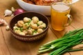 Fried chicken meat and roasted potatoes on a white platter, a glass of beer, champignon mushrooms and green onions, delicious food Royalty Free Stock Photo