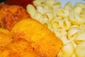 Fried chicken nuggets and cooked pasta on a plate. Close up Royalty Free Stock Photo