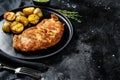 Fried Chicken schnitzel with baked potatoes. Black background. Top view. Copy space Royalty Free Stock Photo