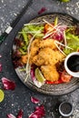 Fried chicken with soy sauce and vegetables on a black plate, view from the top Royalty Free Stock Photo