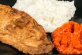 Fried chicken white meat with mashed potatoes and paprika ajvar on the black plate Royalty Free Stock Photo