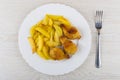 Fried chicken winglets in breading, potato in plate, fork Royalty Free Stock Photo