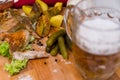 Fried chicken wings with baked potatoes, served on a wooden board with pickled gherkins, tomato sauce and fresh lettuce leaves Royalty Free Stock Photo