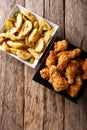 Fried chicken wings in bread crumbs and potato wedges close up. Royalty Free Stock Photo