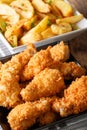 Fried chicken wings in breadcrumbs and potato slices close-up. v Royalty Free Stock Photo
