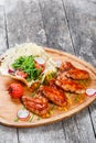 Fried chicken wings with fresh salad, grilled vegetables and bbq sauce on cutting board on wooden background Royalty Free Stock Photo