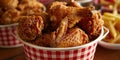 Fried Chicken wings and legs. Bucket full of crispy kentucky fried chicken on red background Royalty Free Stock Photo