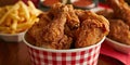 Fried Chicken wings and legs. Bucket full of crispy kentucky fried chicken on red background Royalty Free Stock Photo