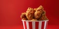 Fried Chicken wings and legs. Bucket full of crispy kentucky fried chicken on red background Royalty Free Stock Photo