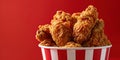 Fried Chicken wings and legs. Bucket full of crispy kentucky fried chicken on red background Royalty Free Stock Photo