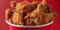 Fried Chicken wings and legs. Bucket full of crispy kentucky fried chicken on red background Royalty Free Stock Photo