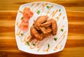 Fried chicken wings served on plate with sauce top view - plate of crispy chicken wings on wooden table Royalty Free Stock Photo