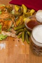 Fried chicken wings with spices and baked potatoes, served on a wooden board with pickled gherkins, tomato sauce and fresh lettuce Royalty Free Stock Photo