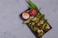 Fried chicken wrapped in pandan leaves in a black plate Royalty Free Stock Photo