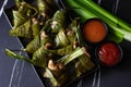 Fried chicken wrapped in pandan leaves in a black plate Royalty Free Stock Photo