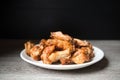Fried chiken wings in the plate on dark Royalty Free Stock Photo