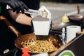 Fried chinese japanese noodles with vegetables and shrimps in takeaway box.Food delivery. Chef putting noodles in carton box to go Royalty Free Stock Photo