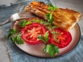 Fried closed sandwich with vegetables on a round plate, close-up