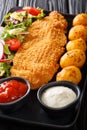 Fried cod fillet in breading with a garnish of new potatoes and fresh vegetable salad close-up on the table. vertical Royalty Free Stock Photo