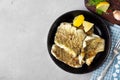 Fried cod fish fillet with spice in a cast iron pan. Royalty Free Stock Photo