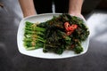 fried cooked green vegetables called kailan served on a restaurant dining table using a white plate
