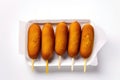 Fried corn dogs on a wooden stick on a white background. Royalty Free Stock Photo
