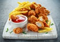 Fried crispy chicken nuggets with french fries and ketchup on white board