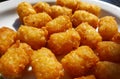 Fried and crispy tator tots on a white plate Royalty Free Stock Photo