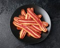 Fried crunchy plant based vegan Bacon pieces in a black plate Royalty Free Stock Photo