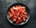 Fried crunchy Streaky Bacon pieces in a black plate Royalty Free Stock Photo