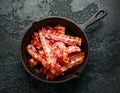 Fried crunchy Streaky Bacon pieces in a cast iron skillet Royalty Free Stock Photo