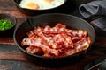 Fried crunchy Streaky Bacon pieces in a cast iron skillet