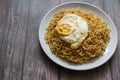 Fried curly noodle with fried egg on top of wooden table ready to be served Royalty Free Stock Photo