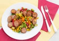 Fried cut sausages and bright vegetables