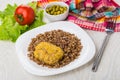 Fried cutlet, buckwheat in plate, tomato on lettuce, green peas