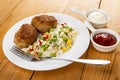 Fried cutlets with hawaiian blend, fork in plate, sauce boats with ketchup and mayonnaise on table Royalty Free Stock Photo