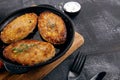 Close up view on burger, cutlets in pan, which stands on cutting board.