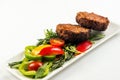 Fried cutlets and vegetable salad white plate on white background Royalty Free Stock Photo