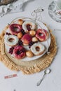 fried donut in glaze, on a plate on a white background, berry background doughnut