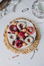 fried donut in glaze, on a plate on a white background, berry background doughnut