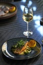 Fried dorado fish and mashed potato on a black plate