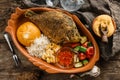 Fried dorado fish with polenta, cheese, scrabble eggs and vegetables on rustic wooden background with Russian vodka drink. Royalty Free Stock Photo